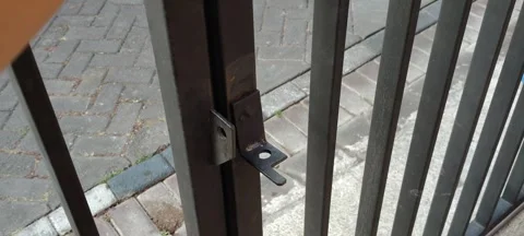 Close up of a hand opening a metal gate latch outdoors. Stock Footage 343556198