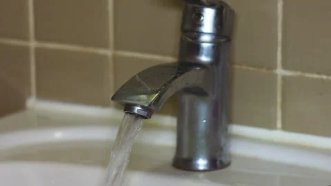 Close-up of Hand Opening a Modern Chrome Bathroom Faucet for Water Flow Stock Footage 337425864