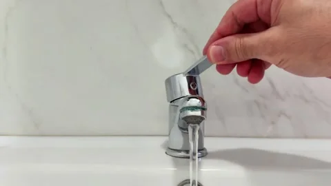 Close Up of Hand Opening Silver Sink Faucet in Bathroom Stock Footage 329094113
