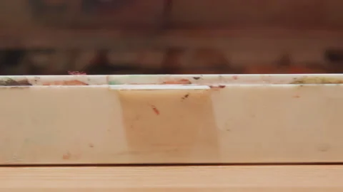 Close up of hand opening stained paint box lid revealing interior details under Stock Footage 345806770