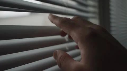 Close up on hand opening window blind or venetian blind to watch or look outside Vídeo Stock 257792588
