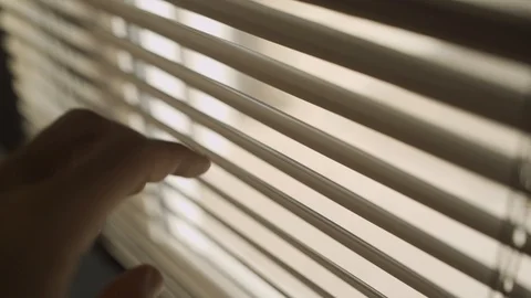 Close up of hand opening window blinds to peek through Stock Footage 109163910
