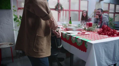 Close up of hand opening wine bottle using corkscrew at Christmas party for Stock Footage 118714739