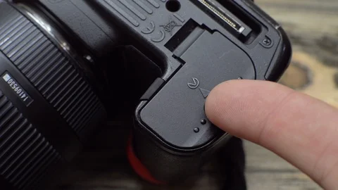 Close-up hand opens battery compartment in camera and removes battery. Stock Footage 119495702