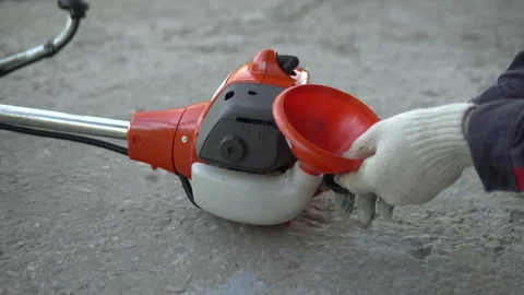 Close-up hand opens the gas tank cover on a lawn mower Stock Footage 131429531