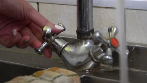 Close-up, a hand opens a water tap. water begins to flow. a stream is pouring Stock Footage 131760836
