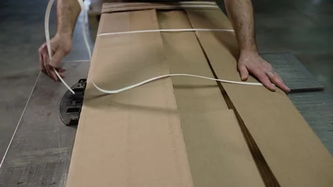 Close-up of a hand packing a cardboard box with tape in a warehouse. Packaging Stock Footage 279313415