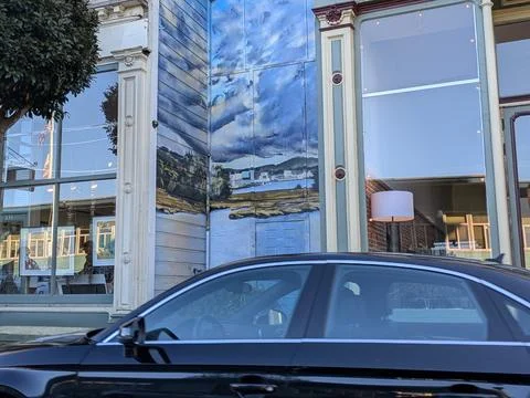 Close-up of hand-painted mural between windows depicting sky Photos