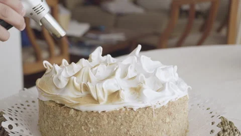 Close up on hand of pastry chef passing blowtorch on meringue Stock Footage 240114004