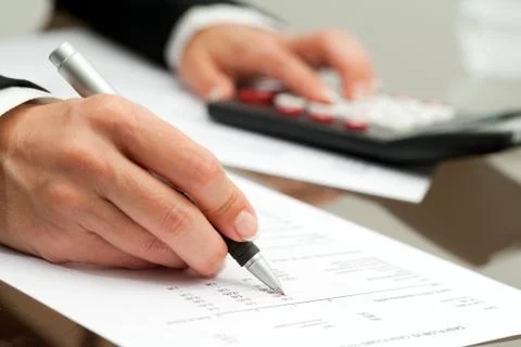 Close up of hand with pen on accounting document. Stock Photos