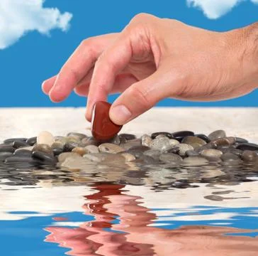 Close up of a hand picking up an agate stone Stock Photos