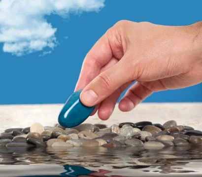 Close up of a hand picking up an agate stone Stock Photos