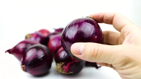 Close Up of Hand Picking Up and Inspecting a Fresh Red Onion Against White .. Stock Footage 322160901
