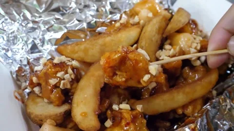 Close-up of Hand Picking Up Crispy Korean Fried Chicken (Dakgangjeong) with a Wo Video stock 343027160