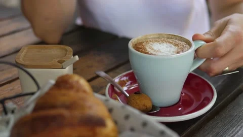 Close up of hand picking a cup of cappuccino to drink. Coffee served with a Stock Footage 146048330