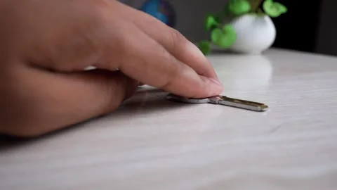 Close-up of a hand picking up a key from a wooden table Stock Footage 317131653