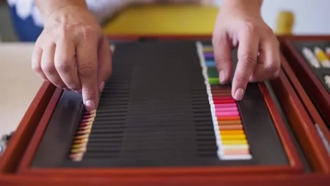 Close-up of hand picking red color pencil from wooden case Stock Footage 130912030