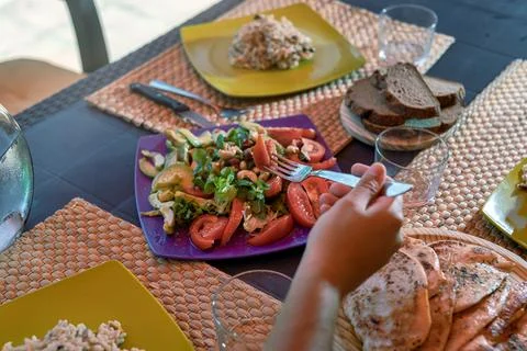 Close-up of a hand picking up salad with a fork at a country lunch Stock Photos