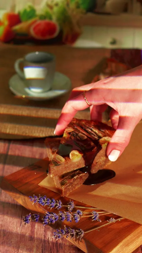 Close-up of a hand picking up a slice of banana bread drizzled with chocolate Stock Footage 306645136