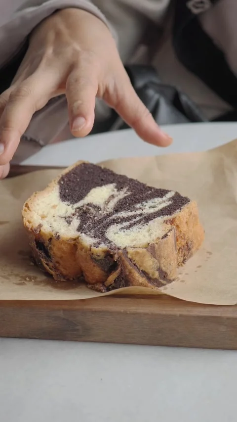 Close-Up of Hand Picking Up a Slice of Marble Cake Stock Footage 336830655