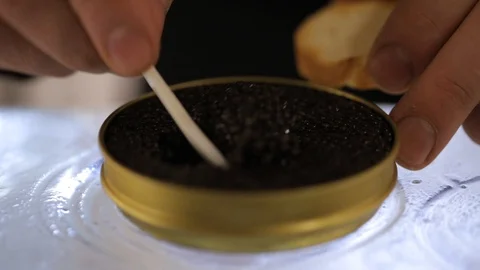 Close up hand picks a spoonful of black caviar. black caviar on the spoon. Stock Footage 127601591