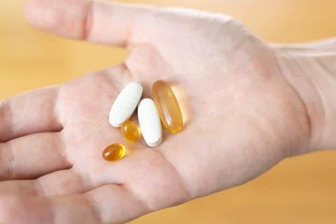 Close up of hand with pills on it. Supplements with omega, vitamin d, magnesium Stock Photos