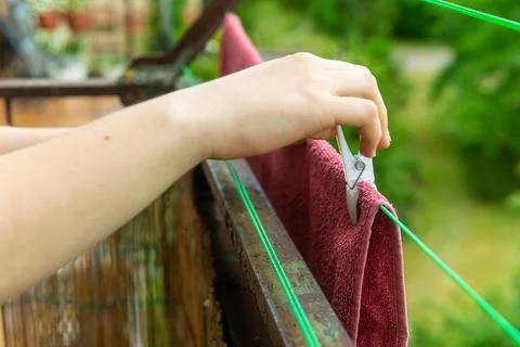 Close up of hand pinning red laundry with peg 写真素材