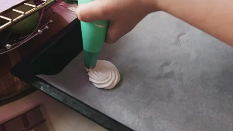 Close Up of Hand Piping White Meringue Onto Baking Parchment Stock Footage 334118965