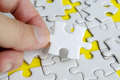 Close up of hand place missing jigsaw puzzle representing problem solving ski Stock Photos