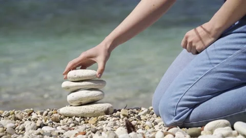 A close-up hand places the top stone on top of the pyramid. The concept of calm. Stock Footage 154397649