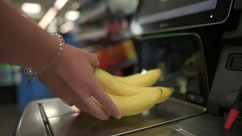 Close-up of hand placing bananas on self-checkout scanner in grocery store Stockbeeldmateriaal 291620786