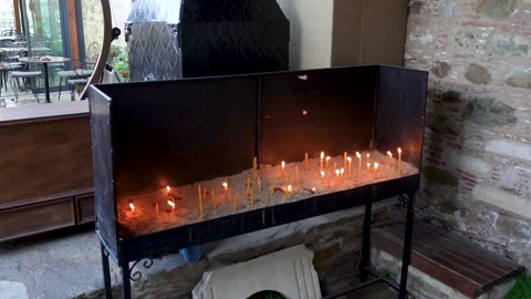 Close up of a hand placing a burning candle in a church Stock Footage 336054474