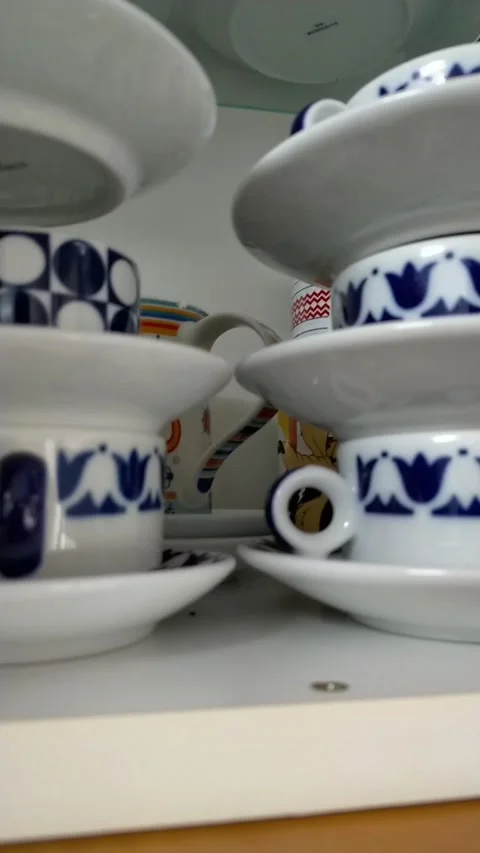 Close up of hand placing ceramic plate and coffee cup on shelf Stock Footage 327190706