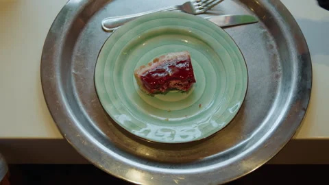 Close up of hand placing pie slice on green ceramic plate with spiral pattern in Stock Footage 347702648