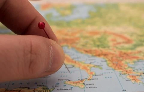 Close up on a hand placing a pin on a map Stock Photos