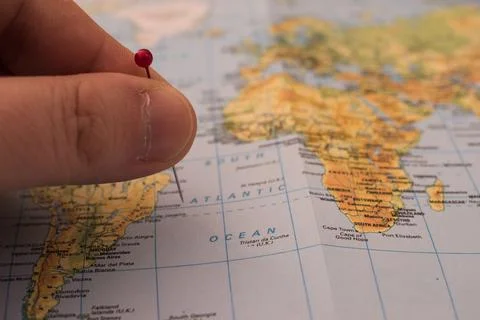 Close up on a hand placing a pin on a map Stock Photos