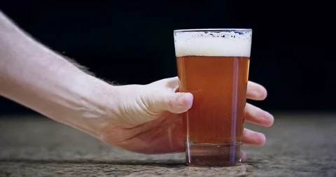Close up of a hand placing a pint of beer on a bar in slow motion 4k Stock Footage 104458994