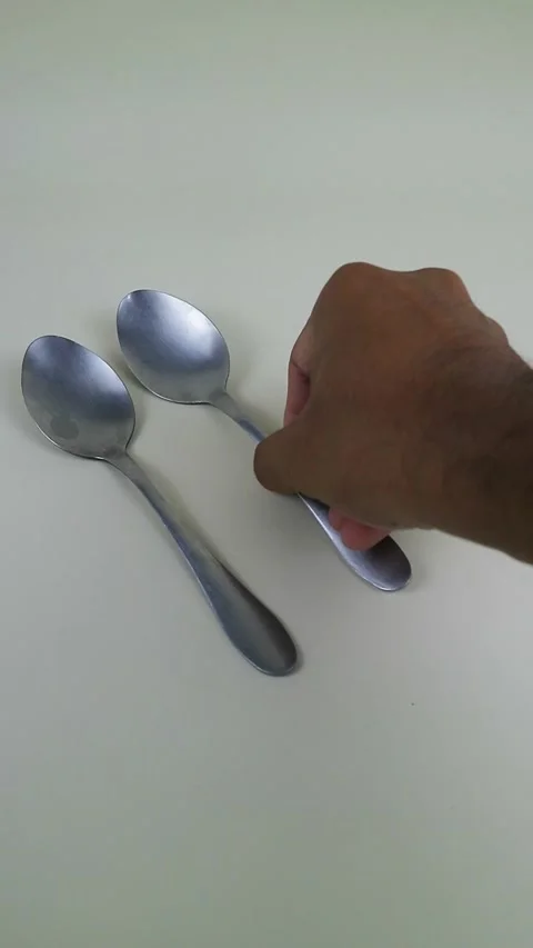 Close Up Hand Placing Three Stainless Steel Spoons on Clean Minimal Backgroun Stock Footage 334022159