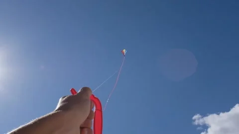 Close up of hand playing and holding a flying kite in the sky Vídeos de archivo 143362777