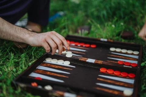 Close-up of a hand playing backgammon on the grass outdoors Stock Photos