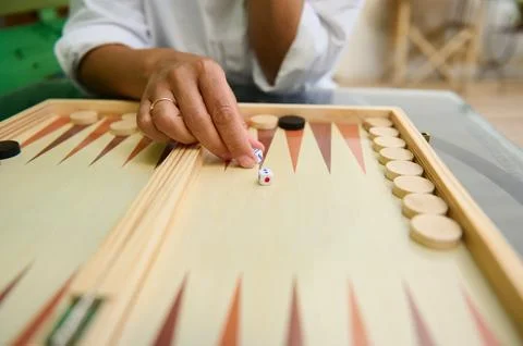 Close-up of hand playing backgammon indoors with wooden pieces Stock Photos