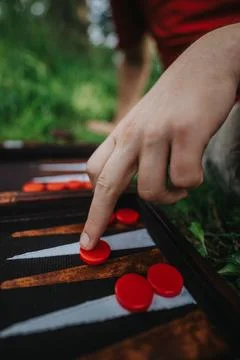 Close-up of hand playing backgammon outdoors on a grassy field Stock Photos