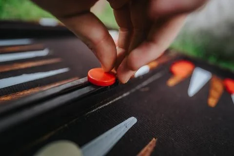 Close-up of hand playing backgammon with red game piece outdoors Stock Photos
