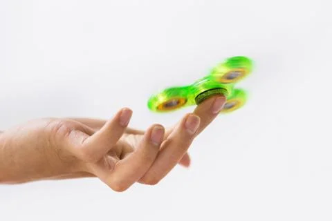 Close up of hand playing with fidget spinner Stock Photos