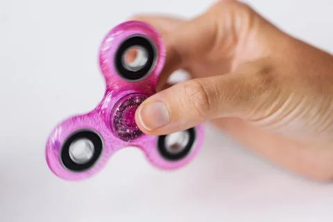 Close up of hand playing with fidget spinner Stock Photos