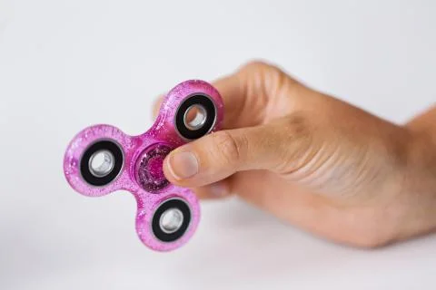 Close up of hand playing with fidget spinner Stock Photos