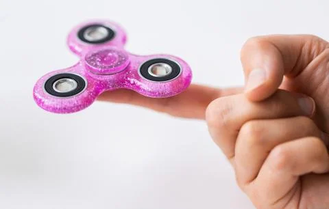 Close up of hand playing with fidget spinner Fotos Stock