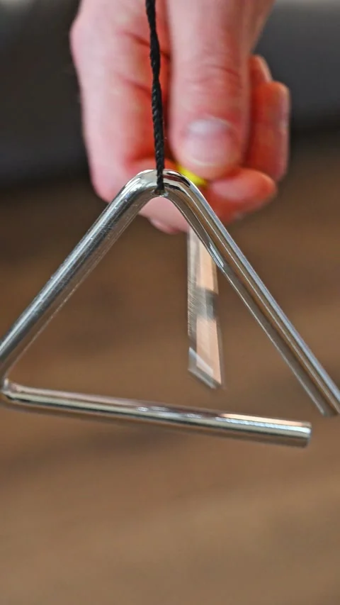 Close-up of Hand Playing Metal Triangle Percussion Instrument Stock Footage 332907602