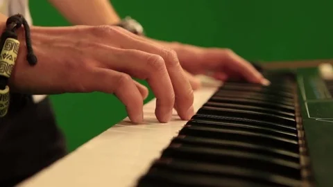 Close-up of hand playing the piano electronic keyboard on green chroma key Stock Footage 81178483