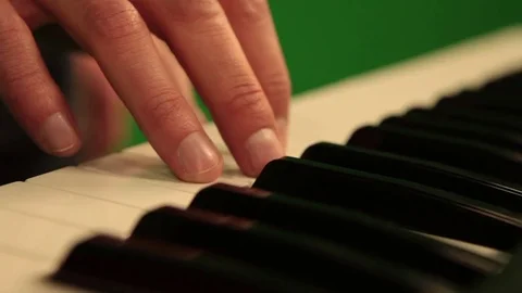 Close-up of hand playing the piano electronic keyboard on green chroma key Stock Footage 81178493